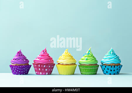 Reihe von bunten Cupcakes auf blau Stockfoto
