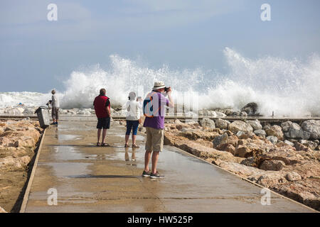 Die Menschen sehen hohe Wellen. Code Orange ist für Gezeiten und Wind gegeben. Fuengirola, Malaga, Andalusien. Spanien Stockfoto