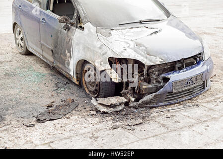 verbranntes Auto auf der Straße Stockfoto