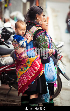 Sapa, Lao Cai, Vietnam - 6. Mai 2014: Ttribal Hmong Frau mit Baby auf der Straße von Sapa, Nord-Vietnam. Stockfoto