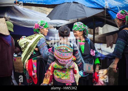 Sapa, Lao Cai, Vietnam - 6. Mai 2014: Porträt der Hmong-Indianerin mit Baby im nationalen Kleidung auf dem lokalen Markt, Sapa, Nord-Vietnam. Stockfoto