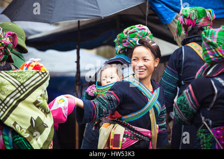 Sapa, Lao Cai, Vietnam - 6. Mai 2014: Porträt der Hmong-Indianerin mit Baby im nationalen Kleidung auf dem lokalen Markt, Sapa, Nord-Vietnam. Stockfoto