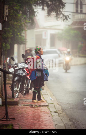 Sapa, Lao Cai, Vietnam - 6. Mai 2014: Ttribal Hmong Frau mit Baby auf der Straße von Sapa, Nord-Vietnam. Stockfoto