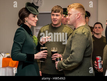 Die Herzogin von Cambridge steht mit einem Pint Guinness in der Hand als sie mit Soldaten des 1. Bataillons Irish Guards in ihrer Kantine nach ihrer St. Patricks Day Parade am Reiterkaserne, Hounslow begegnet. Stockfoto