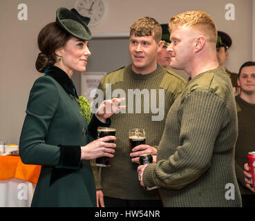 Die Herzogin von Cambridge steht mit einem Pint Guinness in der Hand als sie mit Soldaten des 1. Bataillons Irish Guards in ihrer Kantine nach ihrer St. Patricks Day Parade am Reiterkaserne, Hounslow begegnet. Stockfoto