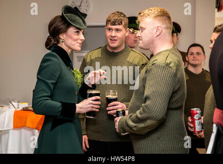 Die Herzogin von Cambridge steht mit einem Pint Guinness in der Hand als sie mit Soldaten des 1. Bataillons Irish Guards in ihrer Kantine nach ihrer St. Patricks Day Parade am Reiterkaserne, Hounslow begegnet. Stockfoto