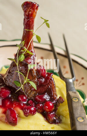 Gebratene Entenkeule mit gestampften Kartoffeln, Äpfel und rote Johannisbeeren in Rotweinsauce Stockfoto