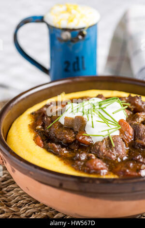 Rindergulasch mit Champignons, Möhren und Maispolenta Stockfoto