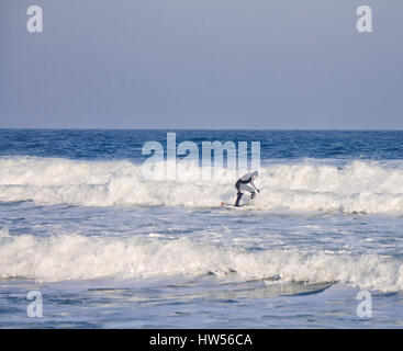 Surfer reitet die Wellen im Wasser einen Neoprenanzug tragen. Wave Splash. wasserdichten Anzug Stockfoto