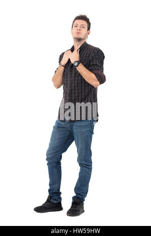 Ernsthafte legerer Mann in Jeans und grauen Hemd mit Kragen ziehen. Ganzkörper-Länge-Porträt über weiße Studio-Hintergrund. Stockfoto