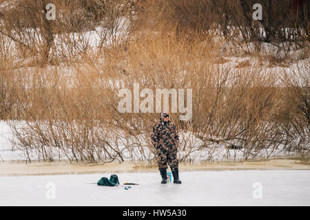 Rogatschew, Belarus - 25. Februar 2017: Fisher am zugefrorenen Fluss am Ende des Winters. Winter Eisangeln ist beliebtes Hobby unter den Weißrussen Menschen. Stockfoto