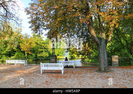 Park Kurpark Wiesbaden (Deutschland) - Person auf Bank, Meerblick - Herbst Herbst, Bäume und Sträucher mit bunten Blättern Stockfoto