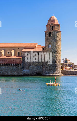 Menschen auf einem Ponton, überragt von der Glockenturm der Kirche von Notre Dame des Anges, Collioure, Côte Vermeille, Frankreich Stockfoto