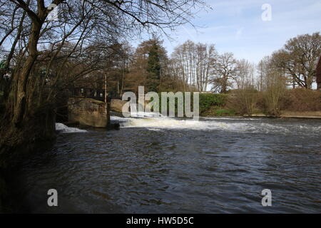 Blick auf den malerischen Fluss an einem sonnigen Tag mit Wasser gießen über ein Wehr Stockfoto