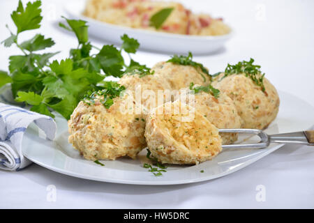 Bayerische Semmelknödel serviert auf einem weißen Teller garniert mit Petersilie Stockfoto