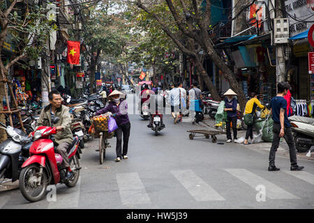 HANOI, VIETNAM - 2. März 2017: Unbekannte Leute auf der Straße von Hanoi, Vietnam. Im Hanoi haben Motorräder Fahrräder als die wichtigste Form der überholt. Stockfoto
