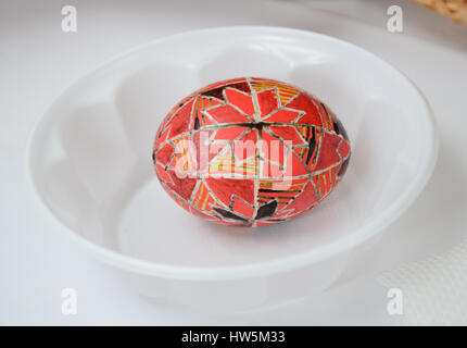 Ein Easter Egg ist mit traditionellen ukrainischen folk Ornament mit einer Wachs-Resist-Methode eingerichtet. Das Pysanka ist mit Wachs und rot gefärbt und gelb bedeckt. Stockfoto