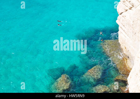 Menschen schwimmen im transparenten türkisen Wasser des balearischen Meer in der Nähe von Cala Mitjana auf Menorca Balearen-Insel in Spanien Stockfoto