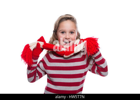 Fröhliches kleines Mädchen tragen gestreifte gestrickte Pullover, Schal und Handschuhe isoliert auf weißem Hintergrund. Winterkleidung Stockfoto