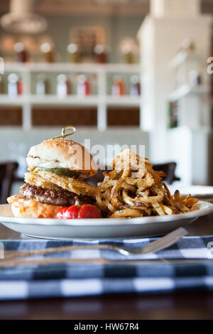 Burger mit Zwiebelringen und Pommes frites Stockfoto