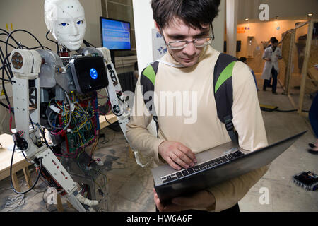 Ein junger Wissenschaftler testen einen menschenähnlichen Roboter bei der Robostation im Moskauer WDNCh Exhibition Center in Russland Stockfoto