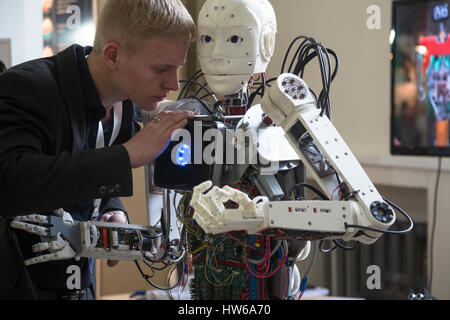 Ein junger Wissenschaftler testen einen menschenähnlichen Roboter bei der Robostation im Moskauer WDNCh Exhibition Center in Russland Stockfoto