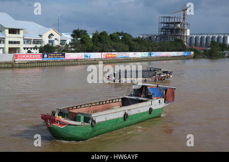 Mekong River in Indochina, einfach Holzboot auf schmutzigen Fluss mit Häusern auf Säulen. einzigartige farbenfrohe Boot Stockfoto