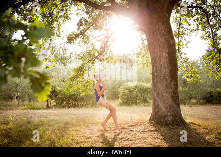 Mädchen in Italien auf einer Schaukel im Hinterhof Stockfoto