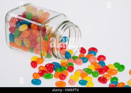Nahaufnahme von eine leckere Jelly Beans Süßigkeit verschüttet aus einem Glas isoliert auf weißem Hintergrund Stockfoto