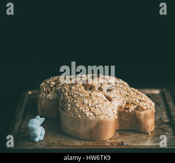 Italienischer Osterkuchen Colomba über einem dunklen Holztisch mit einigen Requisiten Stockfoto