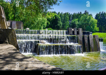 Sommer Landschaft mit Wasserfall. Ein kleiner Wasserfall in einem öffentlichen park Stockfoto