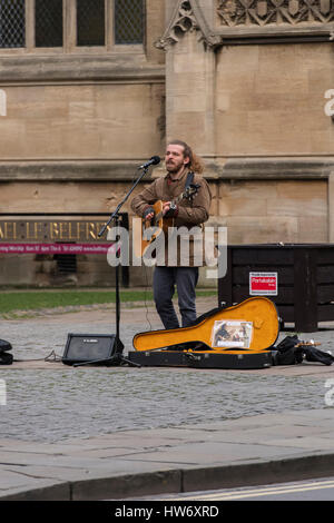 Männliche Gaukler oder street Entertainer live Musik (Gitarre spielen und singen zu Mikrofon) - Hohe Petergate, York, North Yorkshire, England, UK. Stockfoto