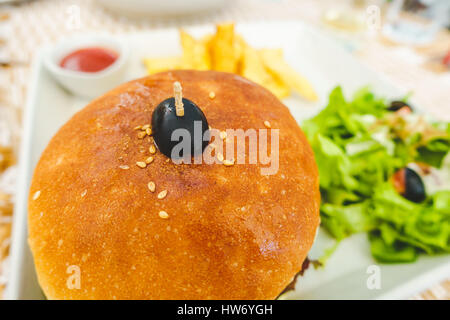 Burger serviert mit Salat, Pommes Frites und Tomatenketchup Stockfoto