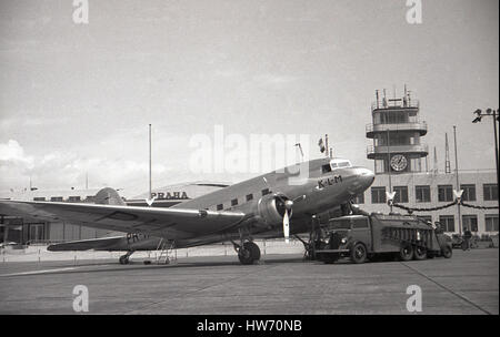 1930er Jahre historische zweimotoriger Ganzmetall-, propellered KLM Flugzeug auf der Landebahn am Flughafen Prag-Ryzyne, Tschechoslowakei, mit Tower im Hintergrund refulled wird Stockfoto