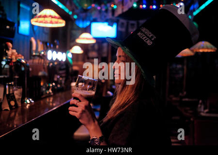 Junge Frau Kobold übergroßen Hut und Biertrinken in Putin Bar während der St. Patricks Day in West-Jerusalem Israel Stockfoto