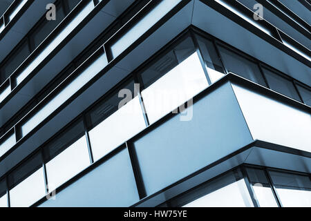 Moderne Industriegebäude Fassade abstrakte Fragment, glänzende Fenster in Stahlkonstruktion, blau getönten Fotohintergrund Stockfoto