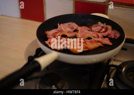 knusprigem Speck in einer Pfanne braten Stockfoto