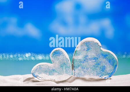 zwei klare Glas Herzen am weißen Sandstrand, Meer, Himmel und Seelandschaft Stockfoto