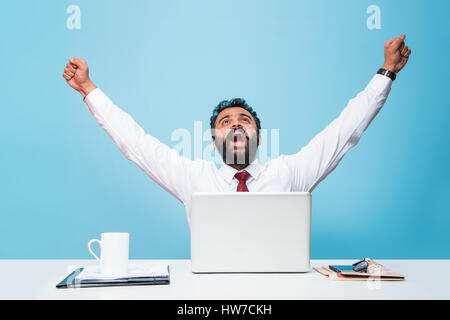 Porträt eines jungen indischen/asiatischen Geschäftsmannes im Bart, sitzend am Bürotisch Stockfoto