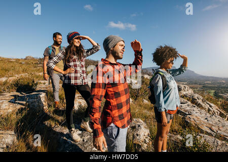 Gruppe der Wanderfreunde genießen die Aussicht vom Gipfel. Junge Männer und Frauen auf Spitze stehend und mit Blick auf einen Blick. Stockfoto