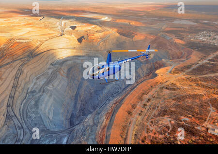 Luftaufnahme von einem Robinson R44 Raven im Flug über die super Grube Kalgoorlie, Westaustralien Stockfoto