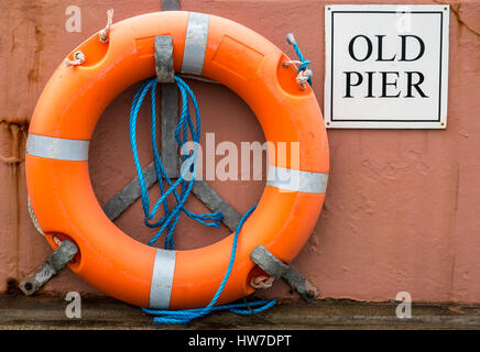 Ein Zeichen der alten Mole und Rettungsring in einem Hafen Stockfoto