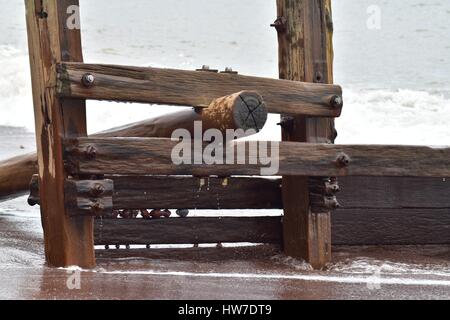 Alte hölzerne Buhne mit Kieselsteinen in Lücken gefangen Stockfoto