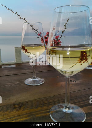Zwei Gläser der weißen Wein und Blüte Zweige zum Meer Stockfoto