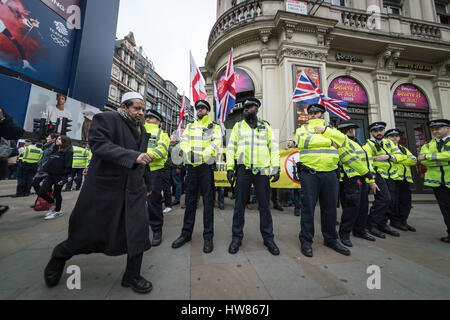 London, UK. 18. März 2017. Ein muslimischer Mann geht vorbei an Britain First rechtsextremen Demonstranten umgeben von traf Polizei auf UN International Anti-Rassismus Tag © Guy Corbishley/Alamy Live News Stockfoto