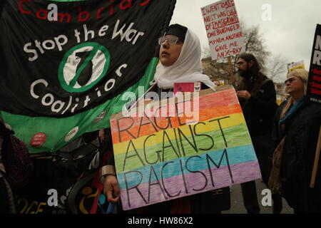 London, UK, 18. März 2017. Kampagnengruppe Stand Up Rassismus hält einen Marsch durch die Londoner anlässlich der UN-Anti-Rassismus-Tag. Eine Frau hält einen Stopp der Krieg-Banner und ein Plakat "Rage Against Racism" zu sagen. Roland Ravenhill / Alamy Live News Stockfoto