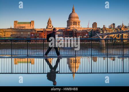 England, London, Southbank, Person spiegelt sich in der Pfütze, in der Nähe von The Millenium Bridge, Morgendämmerung Stockfoto