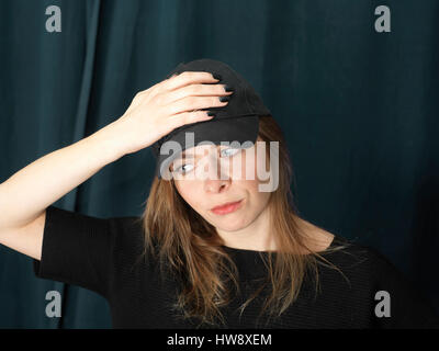 Schöne junge Frau hält einen Kopf in Stress, Studioaufnahme beschnitten Stockfoto