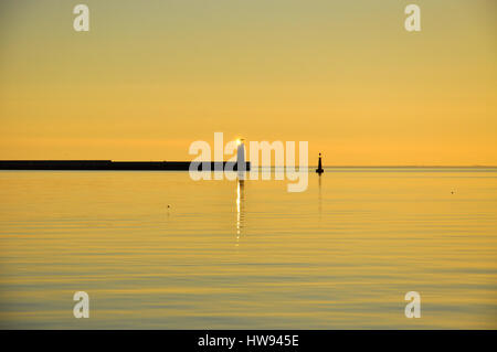 Minimalistische Sonnenaufgang in Pastellfarben. Sonnenaufgang über der Ostsee mit Leuchtturm in Polen Stockfoto