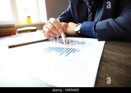 Hand-schreiben auf verschiedenen Finanz-Charts auf dem Tisch Stockfoto